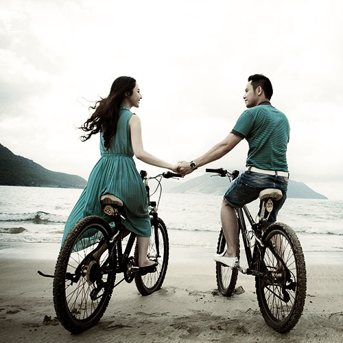 Image of a couple riding bikes on the beach