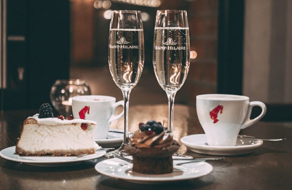 Image of two champagne classes and two desserts on a table